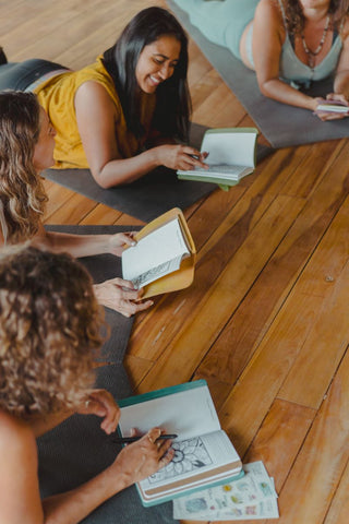 Women smiling while journaling at a retreat