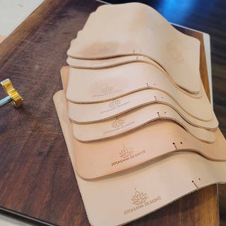 A collection of vegtan leather journals being branded by hand.
