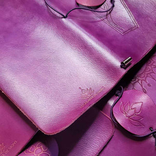 A collection of handcrafted leather journals in a rich amethyst purple color.